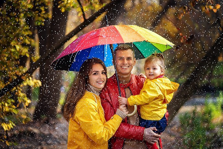 Glückliche Familie unter einem bunten Regenschirm